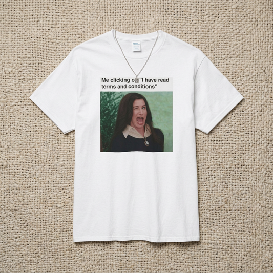 A white t-shirt with a graphic including a winking woman and text stating "Me clicking on 'I have read terms and conditions'" on a textured beige background