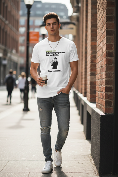 Man wearing a white t-shirt with a graphic design titled 'Lesson one,' with black text under it saying 'Only trust people who like big butts...,' a man with a phone snapping a picture, and another black text under it stating 'they cannot lie', standing on a city street.